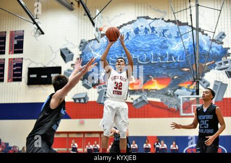 Spieler die Freigabe zum Jump über der Oberseite des Schlüssels und über die Verteidigung bei einem High School Basketball Spiel. USA. Stockfoto