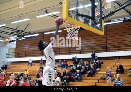 Allein aus dem Boden, ein High School vorwärts slams Home zwei Punkte während eines High School Basketball Spiel. USA. Stockfoto