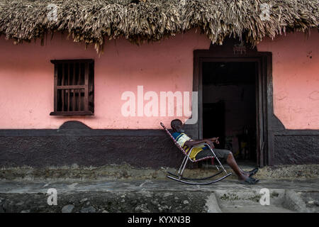 Einem alten Kolumbianischen Mann sitzt in einem Schaukelstuhl vor seinem Haus in San Basilio de Palenque, einem Dorf in der karibischen Region von Kolumbien. Stockfoto