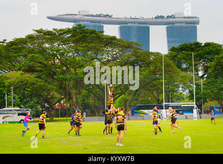 Singapur - Jan 16, 2017: Zwei laienhaften Rugby Team play Rugby in Singapur. Marina Bay Sands Hotel auf dem Hintergrund Stockfoto