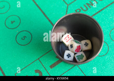Fünf poker Würfel im Becher auf dem Green casino Feld Stockfoto