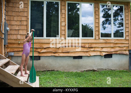 Mädchen mit einem Badeanzug halten oar auf Schritte Stockfoto