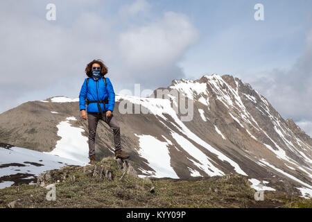 Volle Länge des zuversichtlich Wanderer mit Schal über Mund gegen Berge Stockfoto