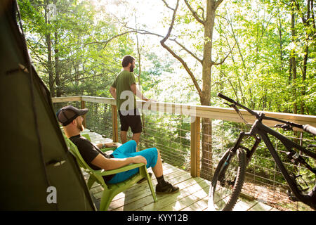 Freunde entspannende durch Zaun am Campingplatz im Wald Stockfoto