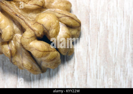 Single geschält Walnuss auf eine Küche aus Holz Schreibtisch in einem Makro Nahaufnahme mit Copy space Raum für Gesundheit essen Designs und Ideen Stockfoto