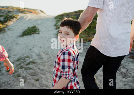 Portrait von Happy, der Sohn mit den Eltern zu Fuß am Strand Stockfoto