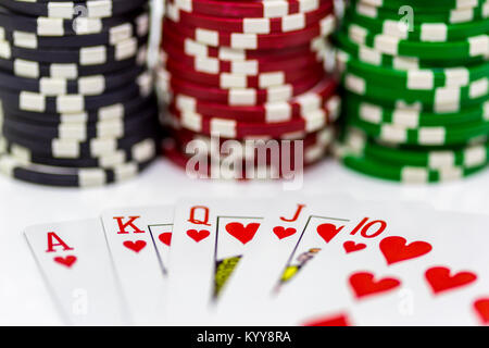Ein Royal Flush mit unscharfen poker chips im Hintergrund auf einem weißen Hintergrund Stockfoto