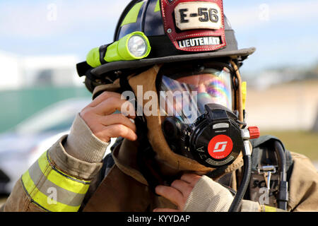 Leutnant José Alfaro der Dade Feuerwehr Hazmat Team, zieht seine Umluftunabhängiges Atemschutzgerät bei einer gemeinsamen Übung von der Dade Feuerwehr und Homestead-Miami Speedway in Miami, Fla., Jan. 11, 2018 gehostet wird. Diese jte konzentrierte sich auf den Aufbau von Kapazitäten und der nahtlose Übergang zwischen den örtlichen Ersthelfern und die Unterstützung durch die Nationalgarde und aktiven Soldaten zur Verfügung gestellt. (U. S. Armee Stockfoto