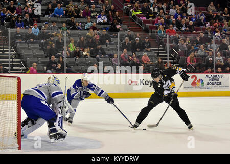 Die Armee von Rick Metcalf von Lakeville, Minnesota, arbeitet ein Schuß hinter der Air Force Tyler Madanski von Charlotte, North Carolina, und goalie Stanislav Barilov von Magadan, Russland, in der 5. jährlichen Armee vs Air Force Hockey Spiel Januar 13, 2018, an der Sullivan Arena in Anchorage. Obwohl die Armee erste zählte, um das Spiel zu starten, Air Force wurde 3-2 Rand in der Reihe mit einem befehlenden 11-1 Shellacking der Armee Skater. (Armee Stockfoto