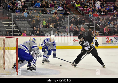 Die Armee von Rick Metcalf von Lakeville, Minnesota, arbeitet ein Schuß hinter der Air Force Tyler Madanski von Charlotte, North Carolina, und goalie Stanislav Barilov von Magadan, Russland, in der 5. jährlichen Armee vs Air Force Hockey Spiel Januar 13, 2018, an der Sullivan Arena in Anchorage. Obwohl die Armee erste zählte, um das Spiel zu starten, Air Force wurde 3-2 Rand in der Reihe mit einem befehlenden 11-1 Shellacking der Armee Skater. (Armee Stockfoto