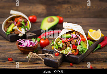 Mexikanische Tacos mit Rindfleisch in Tomatensoße und Avocado Salsa Stockfoto