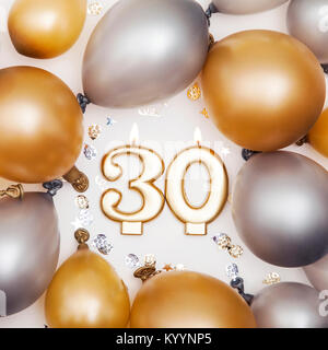 Geburtstag Zahl 30 Kerze mit Gold und Silber Ballons Stockfoto