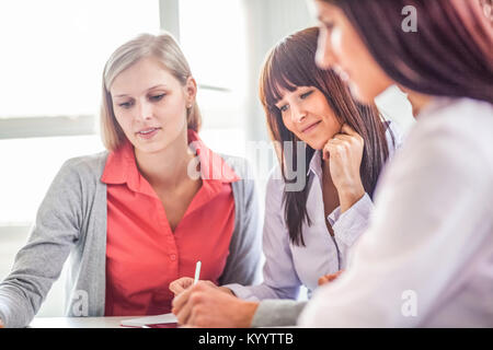 Junge Geschäftsfrau mit weiblichen Kollegen diskutieren im Board Room Stockfoto