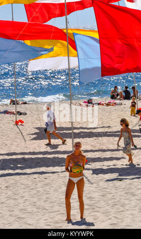 Eine blonde Frau stand vor der Flaggen am Cottesloe Beach, Perth, Western Australia. Stockfoto
