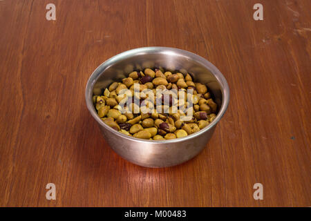 Hausgemachte geröstete Erdnüsse in Edelstahl Schüssel auf hölzernen Tisch Stockfoto