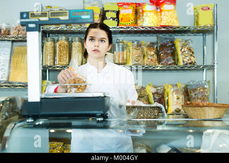 Junge Frau prüft das Gewicht eines Paketes von Cookies in den Store Stockfoto