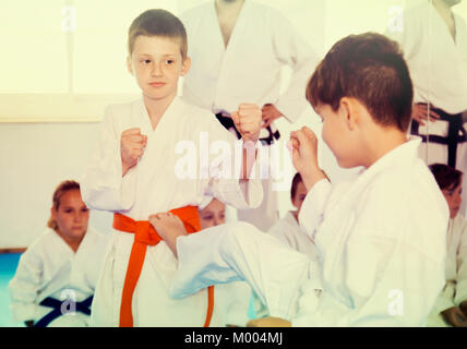 Gewöhnliche boys Ausbildung in paar Karate Technik während der Klasse zu verwenden Stockfoto