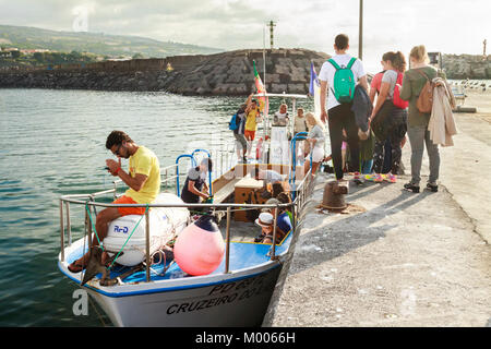 Touristen, die ein Boot besteigen, um von Sao Miguel, Azoren, Portugal, zur Insel Vila Franca do Campo zu reisen Stockfoto