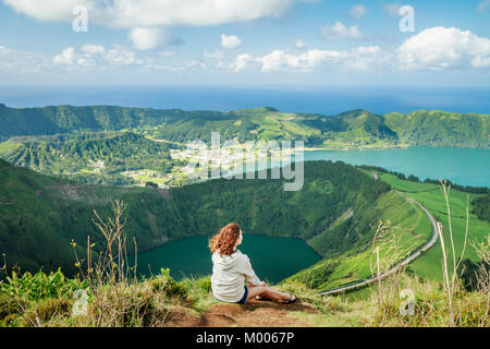 Junge Hikerin genießen die atemberaubende Aussicht auf Sete Cidades Seen vom Aussichtspunkt Miradouro Boca do Inferno, Sao Miguel, Azoren, Portugal Stockfoto