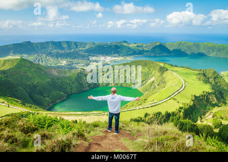 Junger Mann genießen Sie den atemberaubenden Blick von Sete Cidades Seen vom Aussichtspunkt Miradouro Boca do Inferno, Sao Miguel, Azoren, Portugal Stockfoto