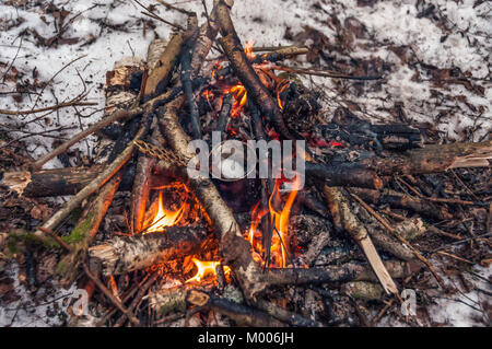 Einen kleinen türkischen Kaffee Topf in einem Lagerfeuer auf te Schnee im Winter Forest Stockfoto