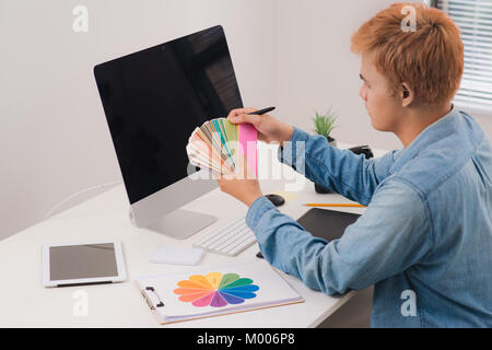 Schwere männliche Graphic Designer bei Bilder in digitale Kamera im Büro suchen Stockfoto