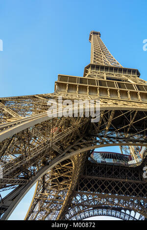 Dynamische Ansicht von unten auf den Eiffelturm gegen den blauen Himmel. Stockfoto