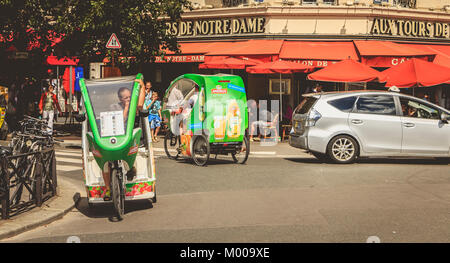 PARIS, Frankreich, 11. Juli 2017: Fahrrad taxis Treiber für Kunden vor der Terrasse eines Restaurants im Sommer warten Stockfoto