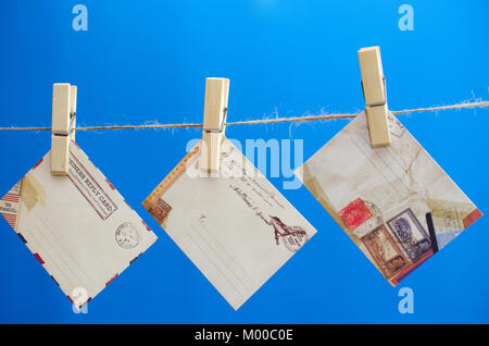 Umschläge der Nachricht auf einem Seil auf einem blauen Hintergrund Stockfoto