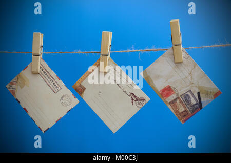 Umschläge der Nachricht auf einem Seil auf einem blauen Hintergrund Stockfoto