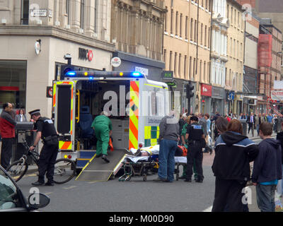 Verletzte Radfahrer mit Fahrrad an der Rückseite des Rettungswagen mit Polizei und Crew in Anwesenheit auf Argyle Street Glasgow gesetzt werden Stockfoto