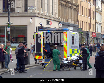 Verletzte Radfahrer mit Fahrrad an der Rückseite des Rettungswagen mit Polizei und Crew in Anwesenheit auf Argyle Street Glasgow gesetzt werden Stockfoto