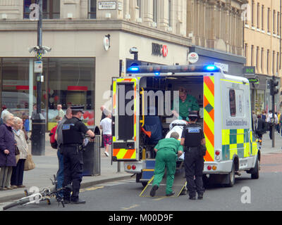 Verletzte Radfahrer mit Fahrrad an der Rückseite des Rettungswagen mit Polizei und Crew in Anwesenheit auf Argyle Street Glasgow gesetzt werden Stockfoto