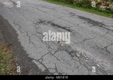 Fahrbahnoberfläche Schaden - schlechte Wartung Qualität. Asphalt Risse in Italien. Stockfoto