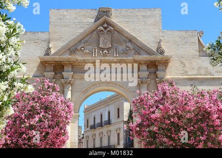 Lecce, Italien - Stadt in der Halbinsel Salento. Oleander Blumen und Porta Napoli Triumphbogen. Stockfoto