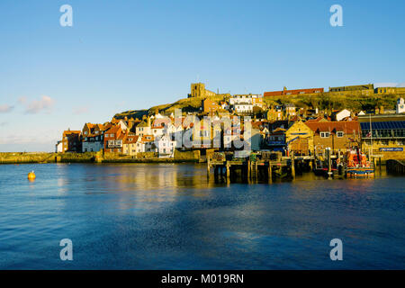 Whitby Hafen mit dem Rettungsboot Station und St. Mary's Church im Winter Sonnenlicht am Nachmittag Stockfoto