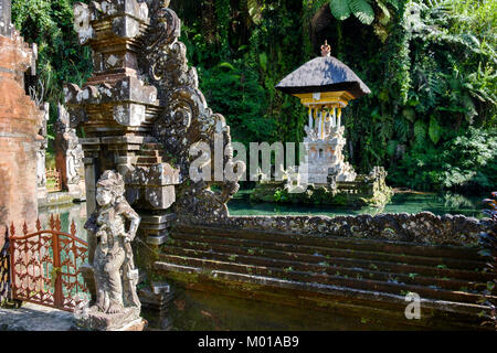 Statue und "Candi bentar' (Split Tor) mit Teich Schrein im Pura Gunung Kawi Sebatu, einem Tempel in der Nähe von Ubud, Bali, Indonesien. Stockfoto