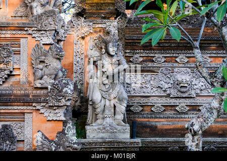 Steinmetzarbeiten und die Statue an der Außenwand eines balinesischen Compound in Ubud, Bali, Indonesien. Stockfoto