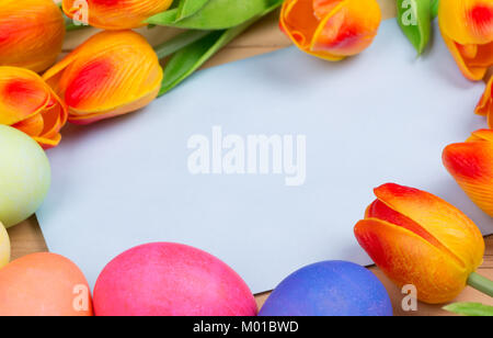 Leere Briefumschlag mit bunten Ostereier und Tulpen umgeben Stockfoto