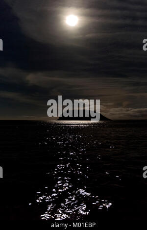 Einen hellen Mond über dem Meer wirft einen schönen, stimmungsvollen Reflexionen auf die glänzende Oberfläche des Wassers Stockfoto