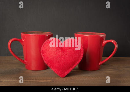 Valentines Tag Komposition mit Rot Kaffeetassen und Herz von Red Velvet Cake über Holz- board mit chalckboard als Hintergrund. Kopieren Sie Platz. Stockfoto