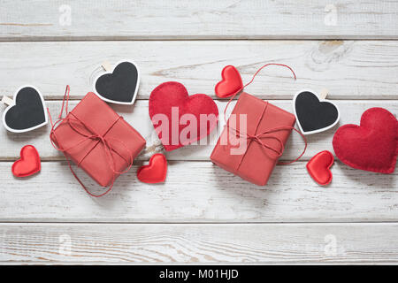 Valentine's Karte. Rot Dekor, Herz, Geschenke auf weißes Holzbrett und Platz für Text auf wäscheklammer. Ansicht von oben. Banner. Ansicht von oben. Stockfoto