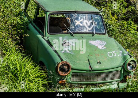 Rusty aufgegeben Vintage grün Trabant. Verfallenes altes Auto sitzt im Gras. Stockfoto