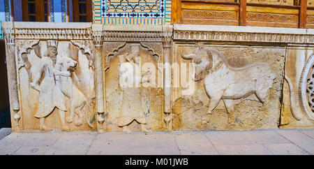 SHIRAZ, IRAN - Oktober 12, 2017: Die steinernen Tafeln an der Fassade des Qavam (Ghavam) Haus in Naranjestan Komplex sind mit Schnitzereien verziert, Darstellung Stockfoto