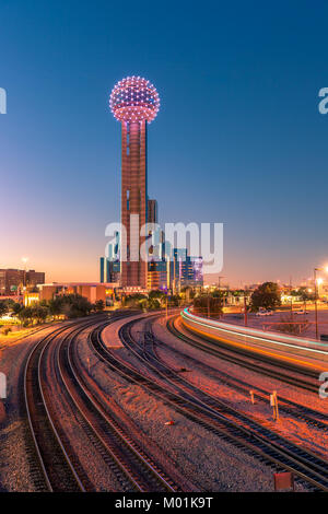 Downtown Dallas bei Sonnenuntergang mit Reunion Tower und leichte Trail aus fahrendem Zug Stockfoto