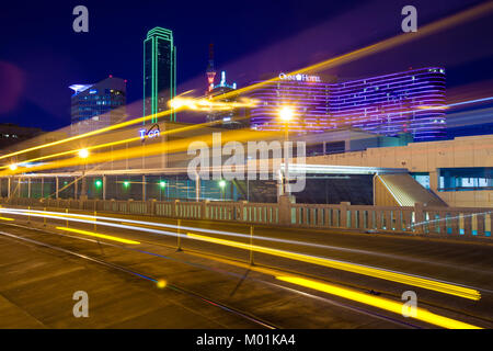 DALLAS, TX - Dezember 10, 2017, - leichte Spuren von beweglichen Straßenbahn auf dem Houston Street mit der Stadt Dallas im Hintergrund. Die Dallas Straßenbahn Stockfoto