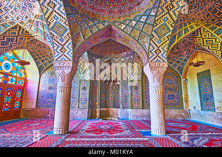 SHIRAZ, IRAN - Oktober 12, 2017: Das Meisterwerk der innerdekoration von Nasir Ol-Molk Moschee - die Fliesen- Muster sind benachbarte mit geschnitzten Stein Stockfoto