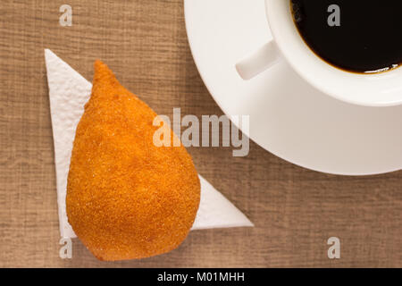 Deep Fried Chicken Finger Food wie Coxinha in Brasilien bekannt. Brasilianer essen, Fast food Alternative oder auf Partys. Snack und Tasse Kaffee auf Holz, Ove Stockfoto