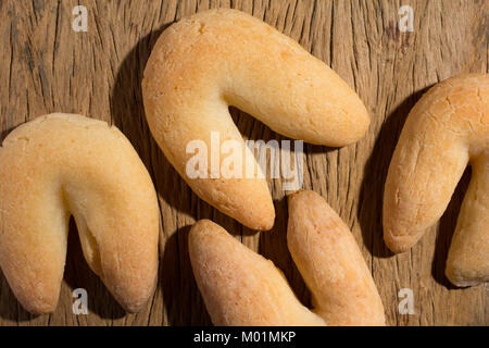 Käse Brot Brötchen als Chipa in Brasilien bekannt, geformt wie ein Hufeisen. Traditionelle Nachmittag Mittagessen. Gruppe von Snacks auf rustikalen, mit Holz, flach Design. Stockfoto