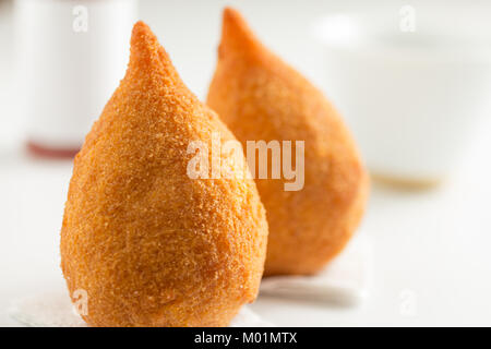 Deep Fried Chicken Finger Food wie Coxinha in Brasilien bekannt. Brasilianer essen, Fast food Alternative oder auf Partys. Zwei Zwischenmahlzeiten auf weißem Hintergrund. Mini Stockfoto